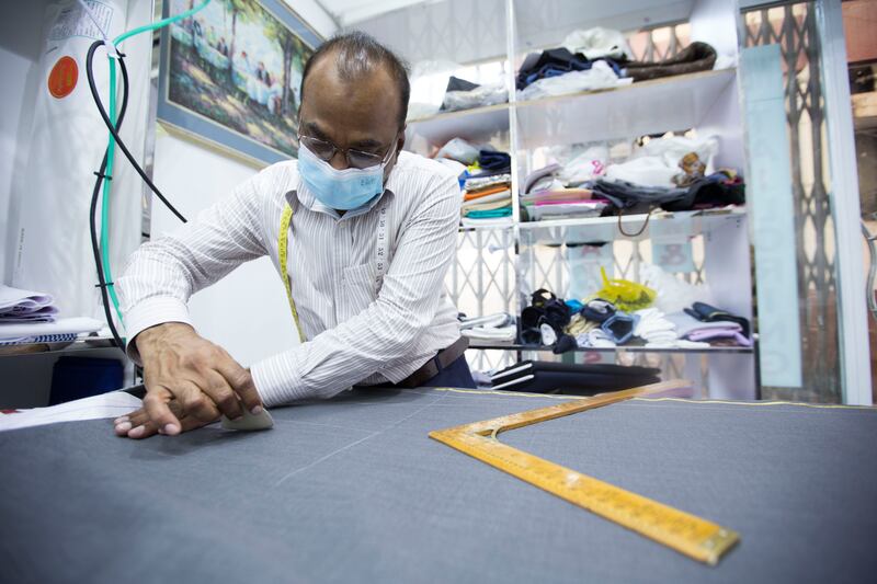 A tailor prepares a piece of cloth at Meena Bazaar.