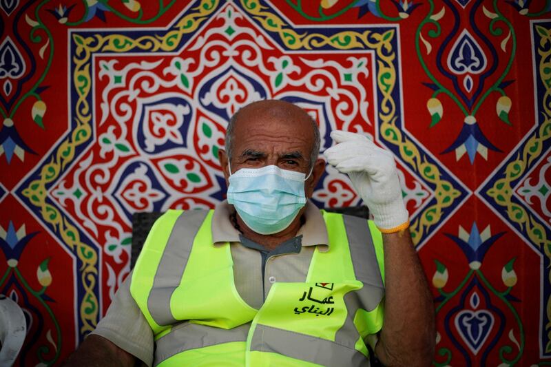 A volunteer from Adliya Charity, wearing a face mask, rests after distributing meals during the month of Ramadan, in Manama, Bahrain. Reuters
