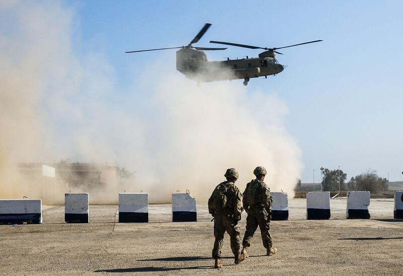 (FILES) In this file photo taken on February 22, 2017, US troops walk as a US C-47 Chinook helicopter flies over the village of Oreij, south of Mosul. The US said on January 10, 2020, it would not discuss pulling troops from Iraq after its caretaker prime minister asked Washington to send a delegation to begin withdrawal arrangements. "At this time, any delegation sent to Iraq would be dedicated to discussing how to best recommit to our strategic partnership -- not to discuss troop withdrawal, but our right, appropriate force posture in the Middle East," State Department spokeswoman Morgan Ortagus said. / AFP / AHMAD AL-RUBAYE
