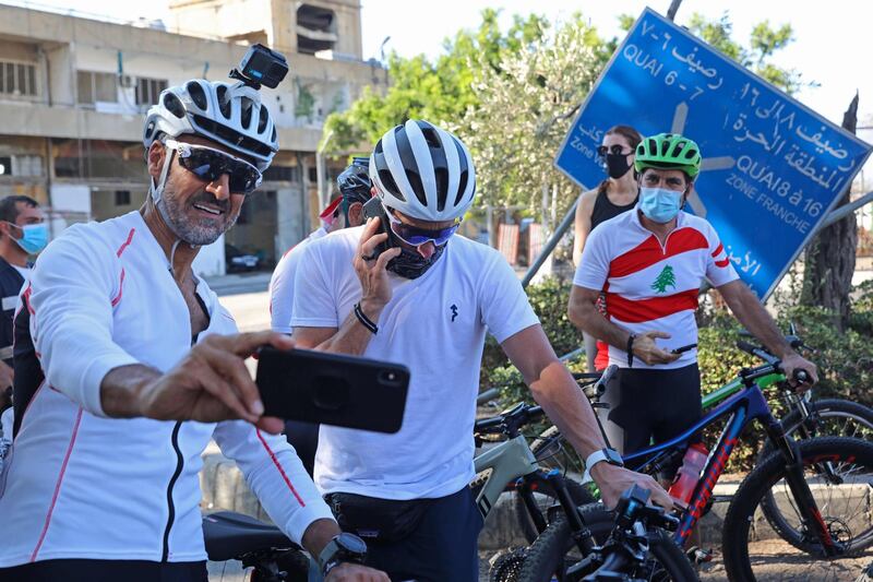 Lebanese sportsman Maxime Chaya takes a picture with US former professional cyclist Lance Armstrong prior to "Bike for Beirut" charity tour at the site of the August 4 port explosion.  AFP