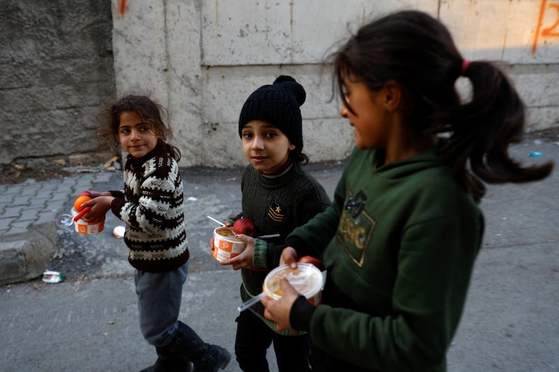 Children walk in the street with food boxes in Kahramanmaras, Turkey. Reuters