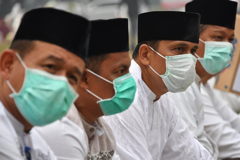 Men wear pollution masks at special prayers asking for rain in Pekanbaru, Riau province. AFP