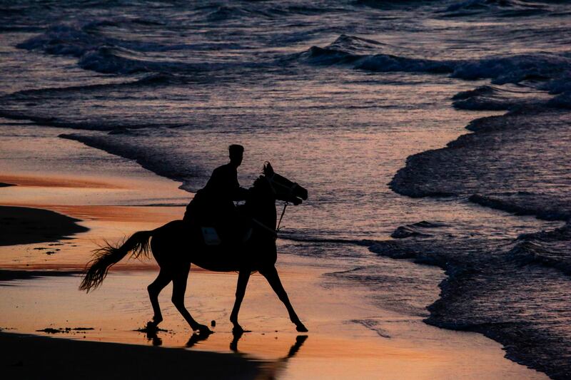 A Palestinian man rides his horse at the beach during sunset, in the west of Gaza City. EPA