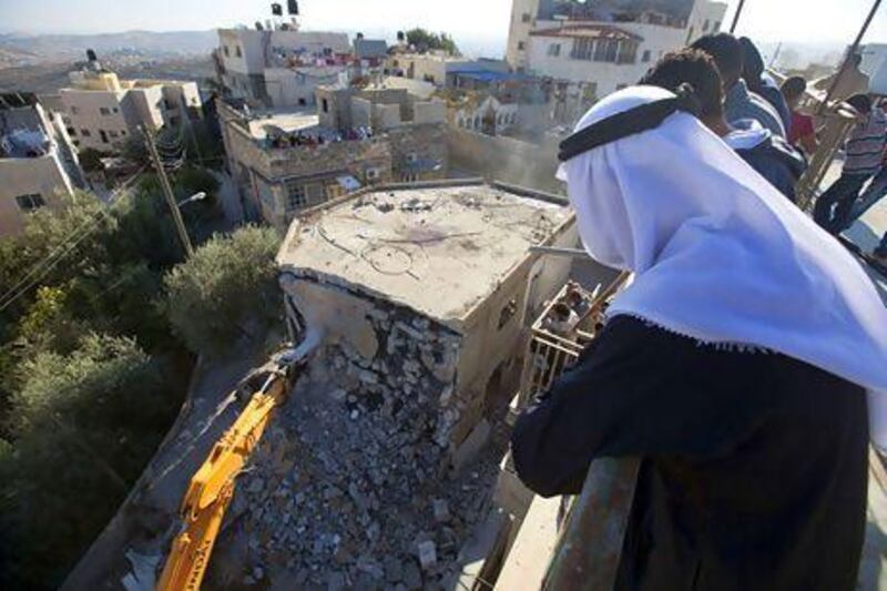 Palestinian Rafet Dabash looks at a bulldozer destroying his own home in the East Jerusalem district of Sur Baher on November 30 after an Israeli court ruled that the house was built without a municipality permit.