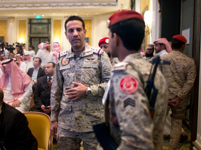 Col. Turki al-Malki, spokesman for the Saudi-led coalition fighting the Huthi forces, speaks to a soldier before a media conference in Khobar city, Saudi Arabia, Monday, April 16, 2018.  Riyadh officials said its air defences intercepted five missiles and two drones, over the past few days. (AP Photo/Amr Nabil)