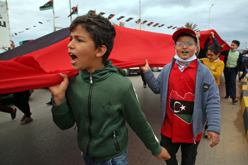 Children carry a giant Libyan flag as part of the celebrations in Tripoli. AFP