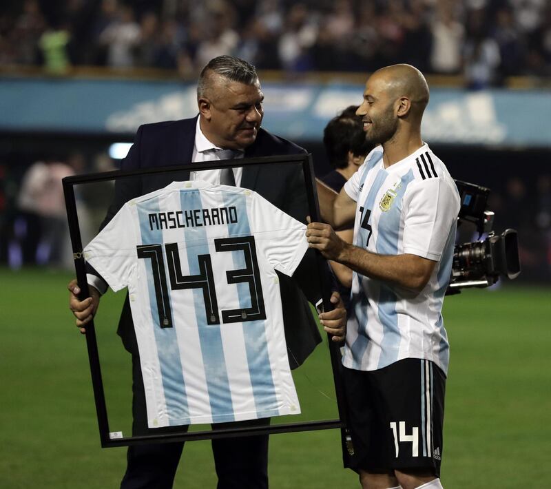 Argentina's Javier Mascherano receives from the president of the Argentine Football Association, Claudio Tapia, a jersey marking his 143th match with the national team. Alejandro Pagni / AFP