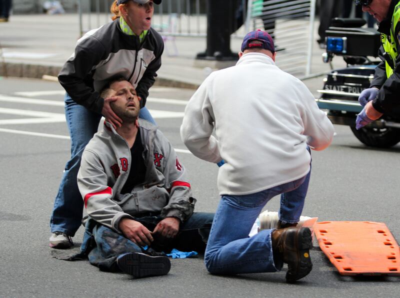 In this photo provided by The Daily Free Press and Kenshin Okubo, people assist an injured after an explosion at the 2013 Boston Marathon in Boston, Monday, April 15, 2013. Two explosions shattered the euphoria of the Boston Marathon finish line on Monday, sending authorities out on the course to carry off the injured while the stragglers were rerouted away from the smoking site of the blasts. (AP Photo/The Daily Free Press, Kenshin Okubo) MANDATORY CREDIT *** Local Caption ***  Boston Marathon Explosions.JPEG-019b3.jpg