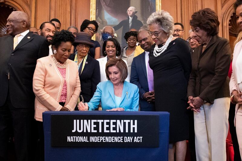 epa09279705 US Speaker of the House Nancy Pelosi (C) signs the 'S. 475, the Juneteenth National Independence Day Act', during a bill enrollment ceremony on Capitol Hill, in Washington, DC, USA, 17 June 2021. When signed by US President Joe Biden, the Juneteenth National Independence Day Act will officially make Juneteenth a federal holiday - a day celebrating the emancipation of African-Americans who had been enslaved in the United States.  EPA/MICHAEL REYNOLDS