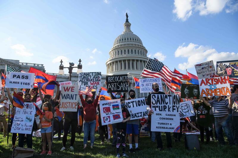 Armenian-Americans hold signs and flags as they protest against the conflict between Azerbaijan and the Armenian enclave of Nagorno-Karabakh and Turkey's support for Azerbaijan in front of the US Capitol in Washington, DC, on October 15, 2020. US Secretary of State Mike Pompeo voiced hope Thursday that Armenia would "defend" itself against Azerbaijan, appearing to show sympathy to one side over the fierce clashes. / AFP / Nicholas Kamm
