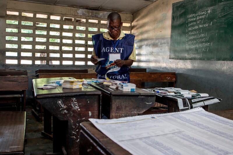 An electoral agent arranges ballots at a polling station in Kinshasa, on December 31, 2018 the morning after the presidential elections. The Democratic Republic of Congo on December 31, 2018 began counting ballots from a presidential election marked by delays and fears of violence and vote-rigging, straining hopes for its first-ever peaceful transfer of power. / AFP / Marco LONGARI
