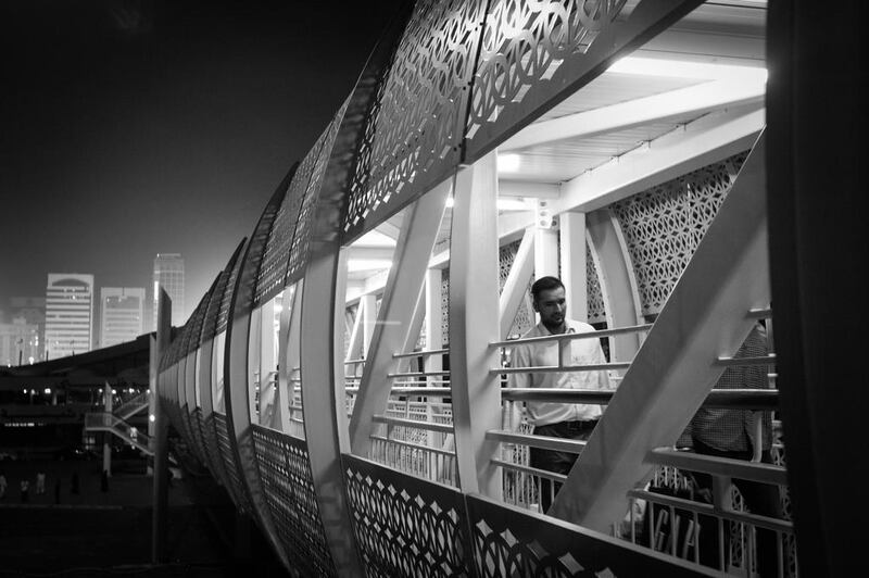 A lone man crosses the pedestrian bridge over Muroor Road near the Abu Dhabi Taxi stand. Brian Kerrigan / The National