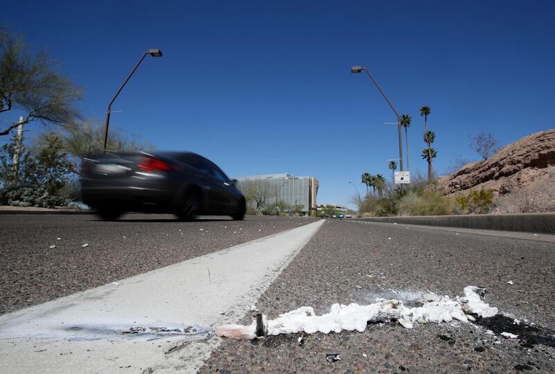 A vehicle goes by the scene of Sunday's fatality where a pedestrian was stuck by an Uber vehicle in autonomous mode, in Tempe, Ariz., Monday, March 19, 2018. A self-driving Uber SUV struck and killed the woman in suburban Phoenix in the first death involving a fully autonomous test vehicle. (AP Photo/Chris Carlson)