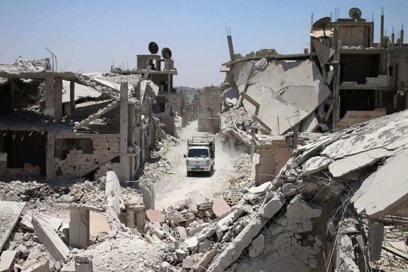 A teuck drives down a destroyed street in a rebel-held area in Daraa on July 19, 2017, as civilians started to return to the area following the July 9 agreement ceasefire brokered by the United States, Russia and Jordan creating a de-escalation zone in Syria's southern Daraa, Quneitra and Sweida regions.  / AFP PHOTO / Mohamad ABAZEED