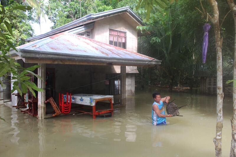 A resident gathers belongings from their flooded house after a tropical depression hit Loboc town, Bohol province, in the central Philippines on January 2, 2018.
Two people were killed and thousands fled strong winds and floods as a tropical depression hit the central Philippines on January 2, following deadly back-to-back storms during the Christmas season.  / AFP PHOTO / MICHAEL LIGALIG