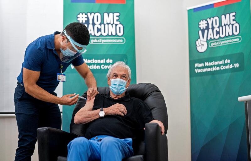 Handout picture released by the Chilean presidency showing Chilean President Sebastian Pinera being inoculated with the Sinovac CoronaVac vaccine against COVID-19 at a healthcare center in Futrono, southern Chile, on February 12, 2021. (Photo by MARCELO SEGURA / CHILE'S PRESIDENCY / AFP) / RESTRICTED TO EDITORIAL USE - MANDATORY CREDIT AFP PHOTO / CHILEAN PRESIDENCY / MARCELO SEGURA - NO MARKETING NO ADVERTISING CAMPAIGNS -DISTRIBUTED AS A SERVICE TO CLIENTS