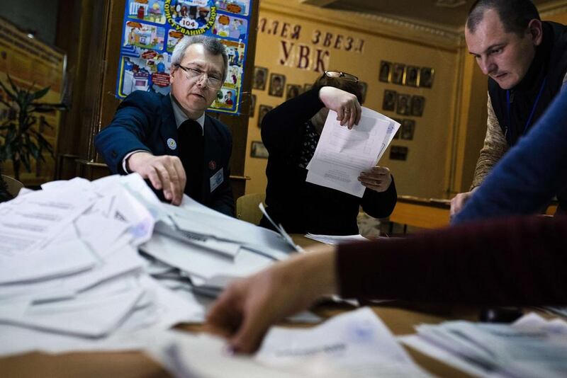 Electoral workers count ballots for the leadership vote in the self-declared Donetsk People's Republic and Lugansk People's Republic at a polling station in the eastern Ukrainian city of Donetsk (AFP PHOTO / DIMITAR DILKOFF)

