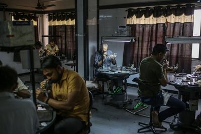 Employees inspect diamonds in the polishing process at a B Virani workshop in Surat, Gujarat, India. At B Virani, which supplies to clients such as Tiffany, employees work 10-hour shifts. Bloomberg