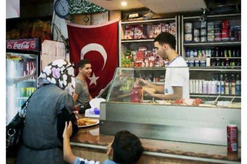 Shoppers at the Abu Al Ez Ardogan Sandwiches Restaurant and Grocery in East Jerusalem. The shop pays homage to the Turkish prime minister. Adam Reynolds for The National