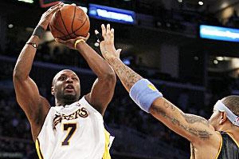The Lakers' Lamar Odom, left, shoots and scores as the Nuggets' Kenyon Martin, right, defends during the second half of their NBA game in Los Angeles on Sunday. The Lakers won 95-89.