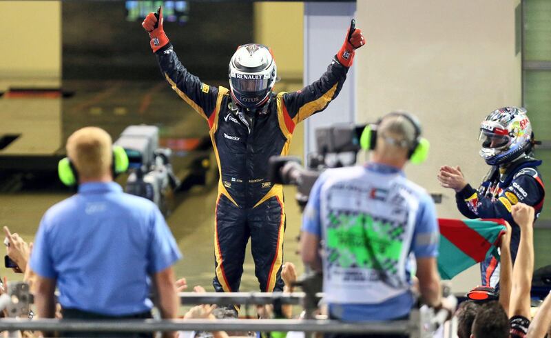 Lotus F1 Team's Finnish driver Kimi Raikkonen (C) and Red Bull Racing's German driver Sebastian Vettel celebrates in the parc ferme at the Yas Marina circuit on November 4, 2012 in Abu Dhabi during the Abu Dhabi Formula One Grand Prix.   AFP PHOTO / MARWAN NAAMANI (Photo by MARWAN NAAMANI / AFP)