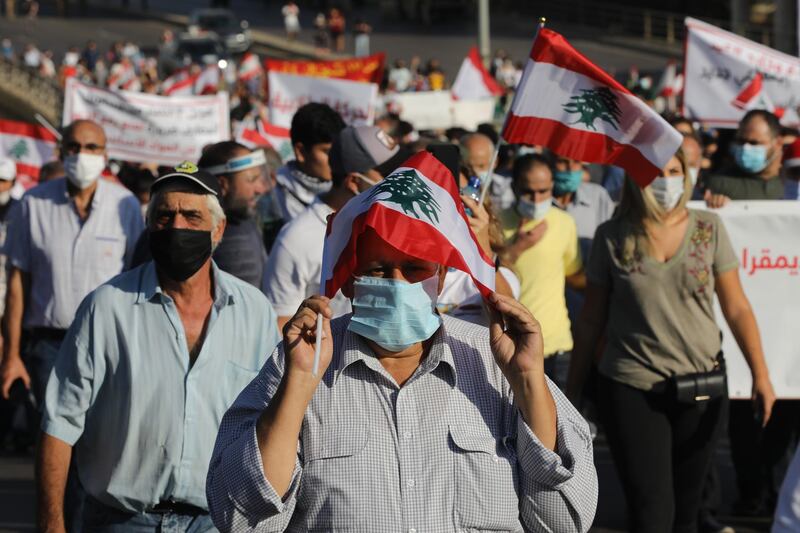 People wave Lebanese flags and chant to mark the first anniversary of anti-government protests. Getty Images