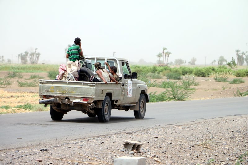 A soldier rides on a pick-up truck during military operations.