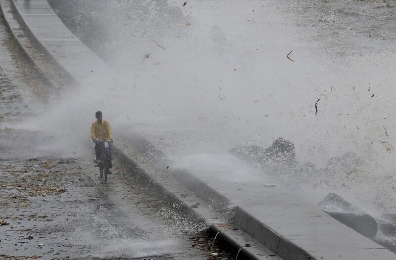 A man rides his bicycle as a wave crashes at a sea front in Mumbai, India. Francis Mascarenhas / Reuters