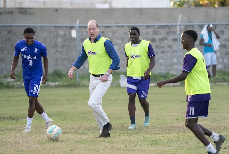 Prince William joins young footballers on the pitch in Kingston, Jamaica.