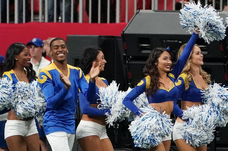 Rams cheerleader Quinton Peron (2nd L) walks onto the pitch with other cheerleaders during Super Bowl LIII between the New England Patriots and the Los Angeles Rams at Mercedes-Benz Stadium in Atlanta, Georgia, on February 3, 2019. (Photo by TIMOTHY A. CLARY / AFP)