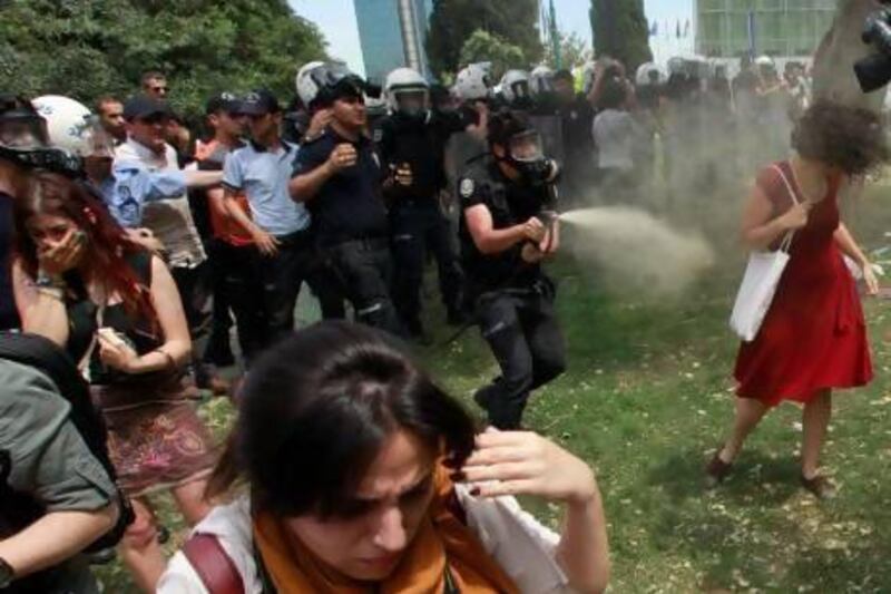 This photograph of a Turkish riot policeman gassing a woman in a red dress in Istanbul last week has been widely circulated. Osman Orsal /Reuters