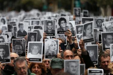 People hold images of the victims of the 1994 bombing attack on the Argentine Israeli Mutual Association (AMIA) community centre. Reuters