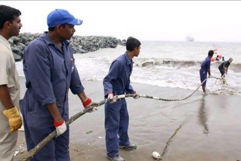 Alcatel-Lucent contractors lay the East African Marine Cable fibre optic cable on the Fujairah shore in 2009. Reuters