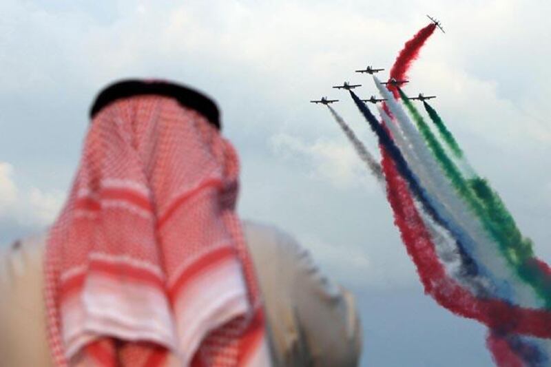 ABU DHABI - UNITED ARAB EMIRATES - 02DEC2012 - A man watching the UAE's premier aerobatic team by al Fursan (the Knights) perform across the Abu Dhabi Corniche to celebrate the 41st UAE National Day yesterday. Ravindranath K / The National 