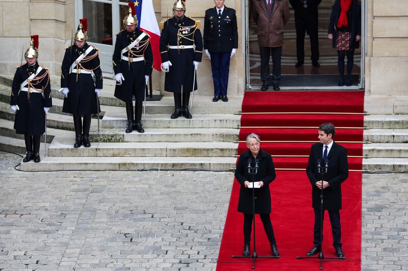 Outgoing Prime Minister Elisabeth Borne stands next to her successor Gabriel Attal as she speaks at the handover ceremony in Paris. EPA