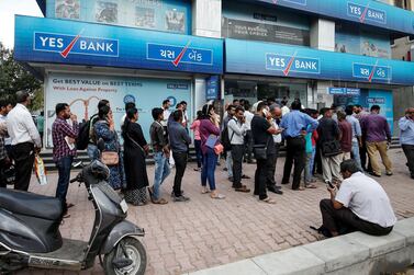 People wait outside a Yes Bank branch to withdraw their money in Ahmedabad - the lender has collapsed heap of bad loans.  Reuters 