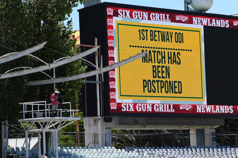 Empty stands and a message of the match postponement on the screen are seen at Newlands stadium in Cape Town, South Africa, on December 4, 2020. The first one-day international (ODI) cricket match between South Africa and England has been postponed after a South African player tested positive for COVID-19. / AFP / Rodger BOSCH

