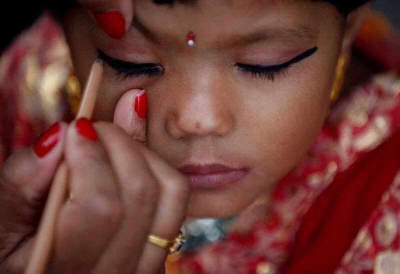 A woman applies makeup to a young girl dressed as the Living Goddess Kumari during the Kumari Puja festival in Kathmandu, Nepal. The festival is a gathering in which young girls pose as the Living Goddess Kumari and are worshipped by people in belief that their children will remain healthy. Navesh Chitrakar / Reuters