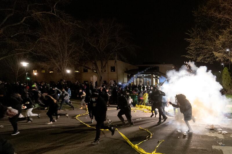 People run for cover as police attempt to disperse the crowd protesting against the death of a 20-year-old man after being shot by police at the Brooklyn Centre Police Department in Brooklyn Centre, Minnesota. AP