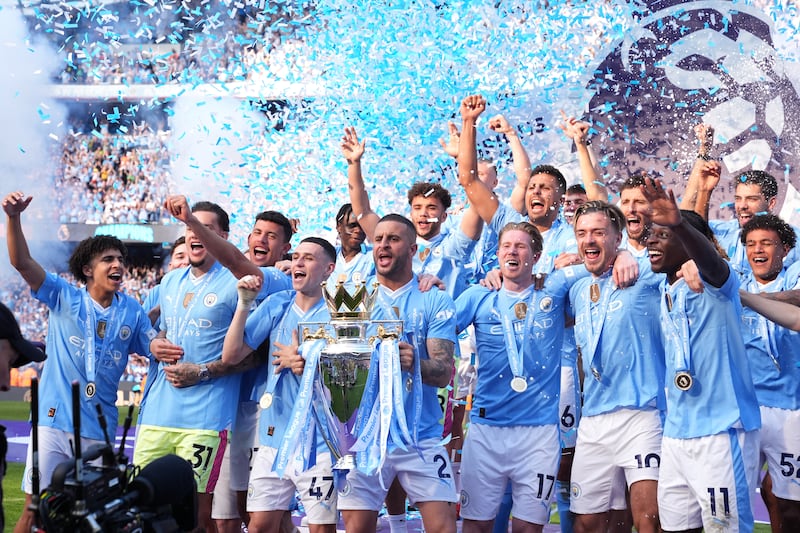 Manchester City captain Kyle Walker lifts the Premier League trophy with teammates after their 3-1 victory over West Ham at the Etihad Stadium clinched a record fourth consecutive title on Sunday, May 19, 2024. PA 