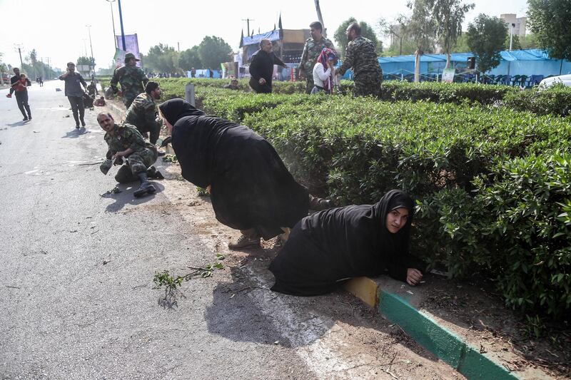 Iranian soldiers, women, and children lay down and run during the attack. EPA