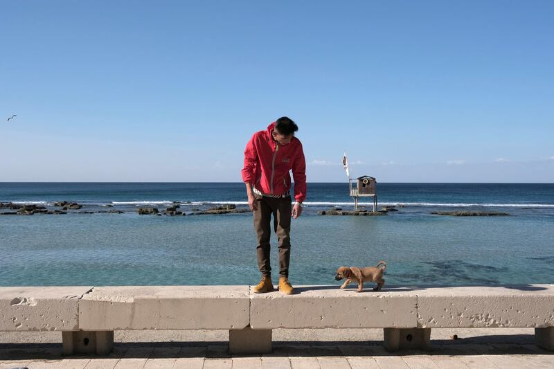 A man looks at his dog on the beach in Benghazi, Libya. Reuters
