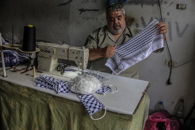 Abu Ghabin at his sewing machine.  EPA