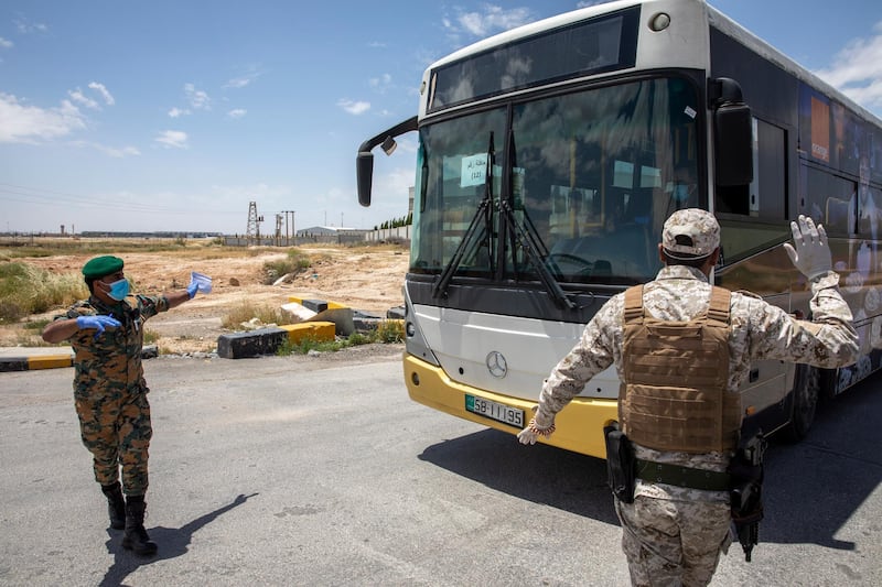 Members of Jordan's security forces check a bus that will transport returning Jordanian students from abroad, at the Queen Alia International Airport, Amman, Jordan.  EPA