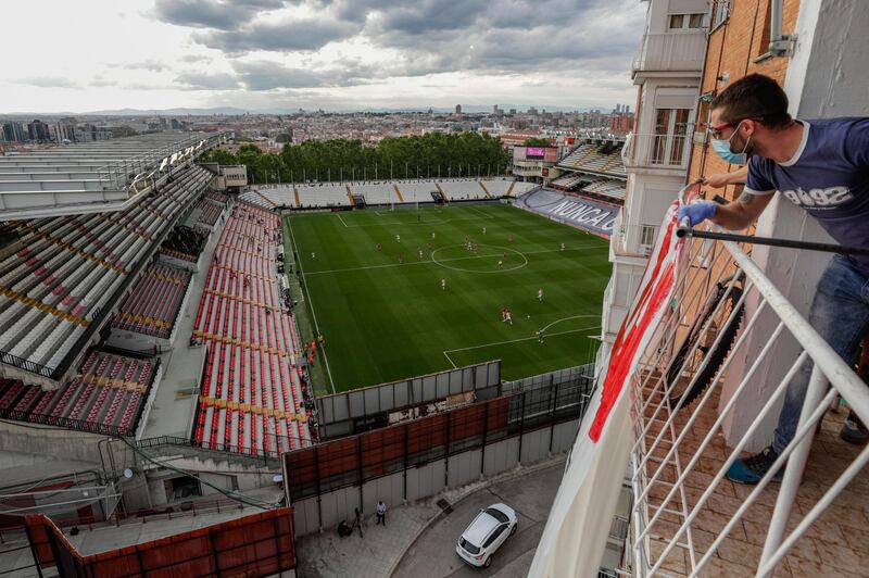 A man on a balcony watches the second-division game between Rayo Vallecano and Albacete in Madrid, Spain, on June 10, 2020.  AP Photo
