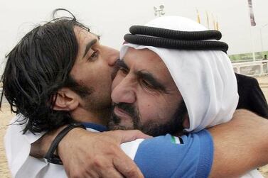 A file picture taken on December 14, 2006 of Vice President and Ruler of Dubai Sheikh Mohammed bin Rashid hugging his son Sheikh Rashid bin Mohammed who finished first in the equestrian endurance competition during the 15th Asian Games in the desert outside Doha. Khaled Nofal / AFP Photo