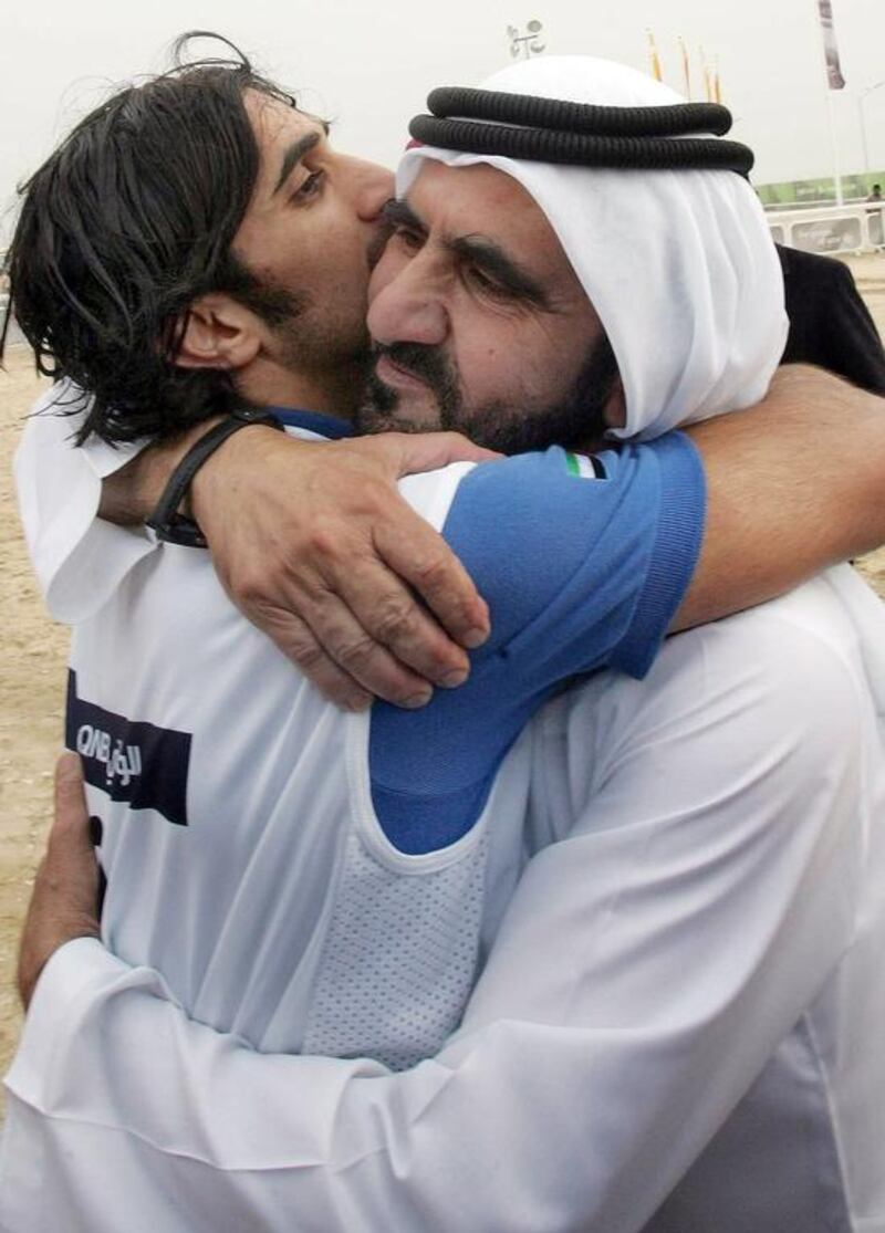 A file picture taken on December 14, 2006 of Vice President and Ruler of Dubai Sheikh Mohammed bin Rashid hugging his son Sheikh Rashid bin Mohammed who finished first in the equestrian endurance competition during the 15th Asian Games in the desert outside Doha. Khaled Nofal / AFP Photo