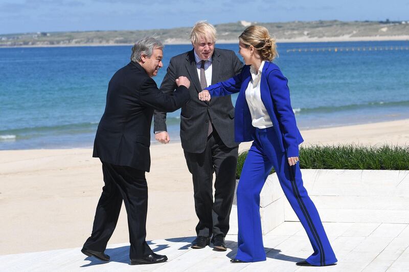 Carrie Johnson (R) welcomes UN Secretary-General Antonio Guterres to the G7 summit in Carbis Bay, Cornwall, wearing a bright blue suit from British designer Amanda Wakeley. AFP
