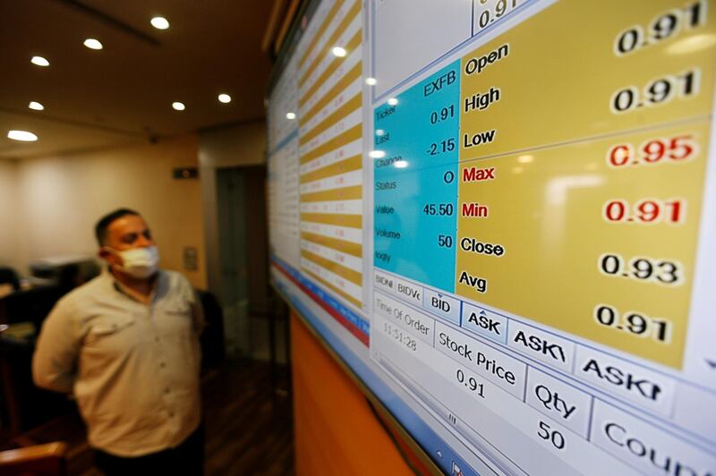 A dealer monitors price movements on an electronic board at the Amman Stock Exchange after it was reopened following 50-day halt over aimed at containing the spread of the coronavirus disease (COVID-19), in Amman, Jordan May 10, 2020. REUTERS/Muhammad Hamed