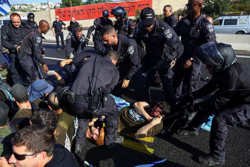 Members of the Israeli security forces remove demonstrators blocking a highway to Jerusalem. Reuters